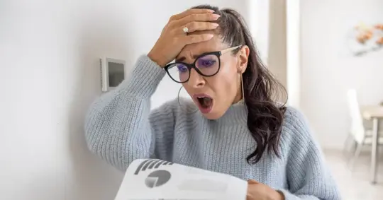 Woman shocked from the rising energy costs and the heating and electricity bill